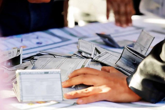 Funcionario electoral revisando las listas de electores