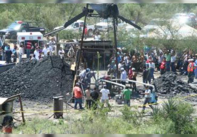 Fotografía cedida por La Voz de Sabinas de rescatistas y trabajadores recuperando un cuerpo el miércoles 25 de julio de 2012, en la mina 