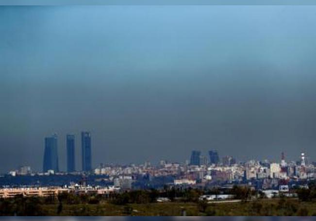 Vista de Madrid con el parque empresarial de las Cuatro Torres (i), en el Paseo de la Castellana de Madrid, y las Torres Kio (d), cubiertas por la 'boina' de contaminación. EFE/Archivo/Juan Carlos Hidalgo