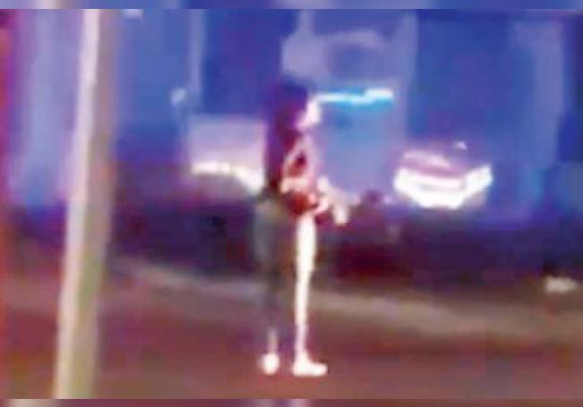 Imagen extraída del video que muestra a la mujer con el arma del uniformado.