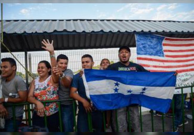 Migrantes centroamericanos saludan a la secretaria de Gobernación de México, Olga Sánchez Cordero (fuera de cuadro), durante su visita a las personas que han decidido acogerse a la tarjeta humanitaria, el miércoles 23 de enero, en Ciudad Hidalgo (México).