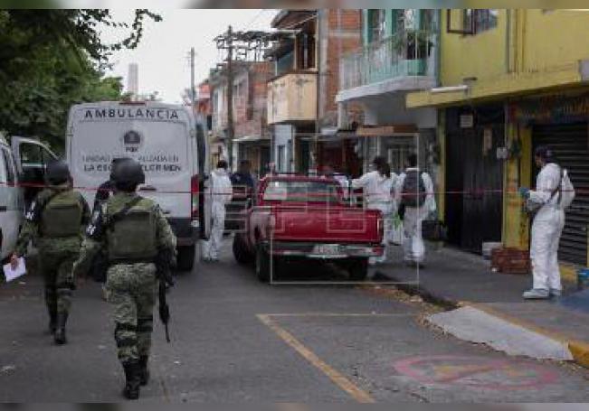 Fotografía de archivo fechada el 4 de septiembre de 2019, que muestra a elementos de la Guardia Nacional y peritos forenses mientras asisten a la escena de un crimen, en Morelia (México).