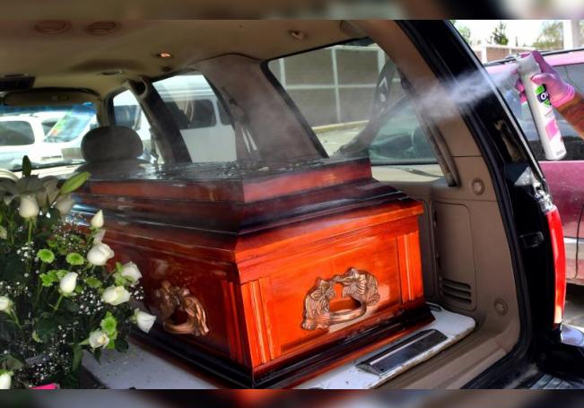 Un empleado funerario desinfecta un féretro cuya persona habría fallecido por COVID-19, el 2 de agosto de 2020 en Ciudad de México (México). EFE/Jorge Núñez/Archivo