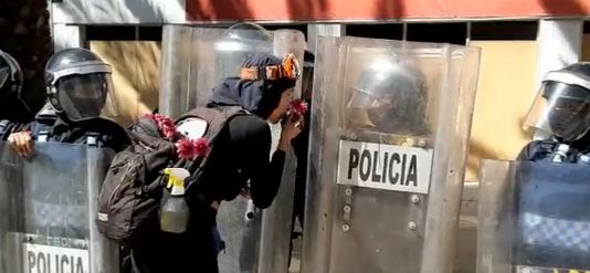 Una feminista regala flores y da un beso en la mano a mujer policía