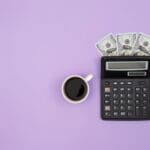 calculator cup of coffee and dollar bills on colo 2023 11 27 05 33 32 utc scaled 1