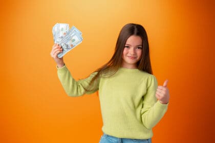 happy teenage girl holding lots of money against o 2023 11 27 05 21 36 utc scaled 1