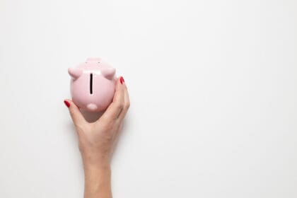 person hand holding pig piggy bank with money on g 2023 11 27 05 00 59 utc scaled 1