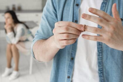 close up father taking wedding ring off
