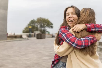 medium shot happy friends hugging outside 1
