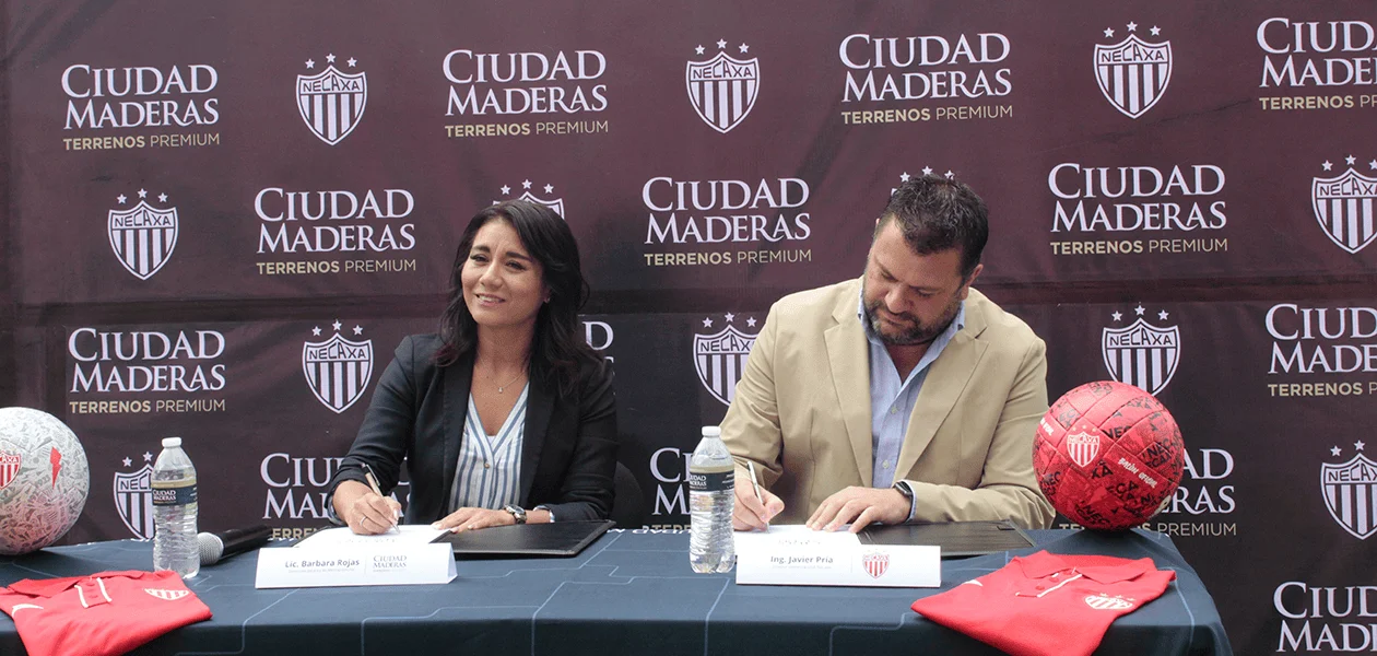 Bárbara Rojas, directora de mercadotecnia de Ciudad Maderas y Francisco Javier Pría director comercial de Club Necaxa, durante la firma de convenio